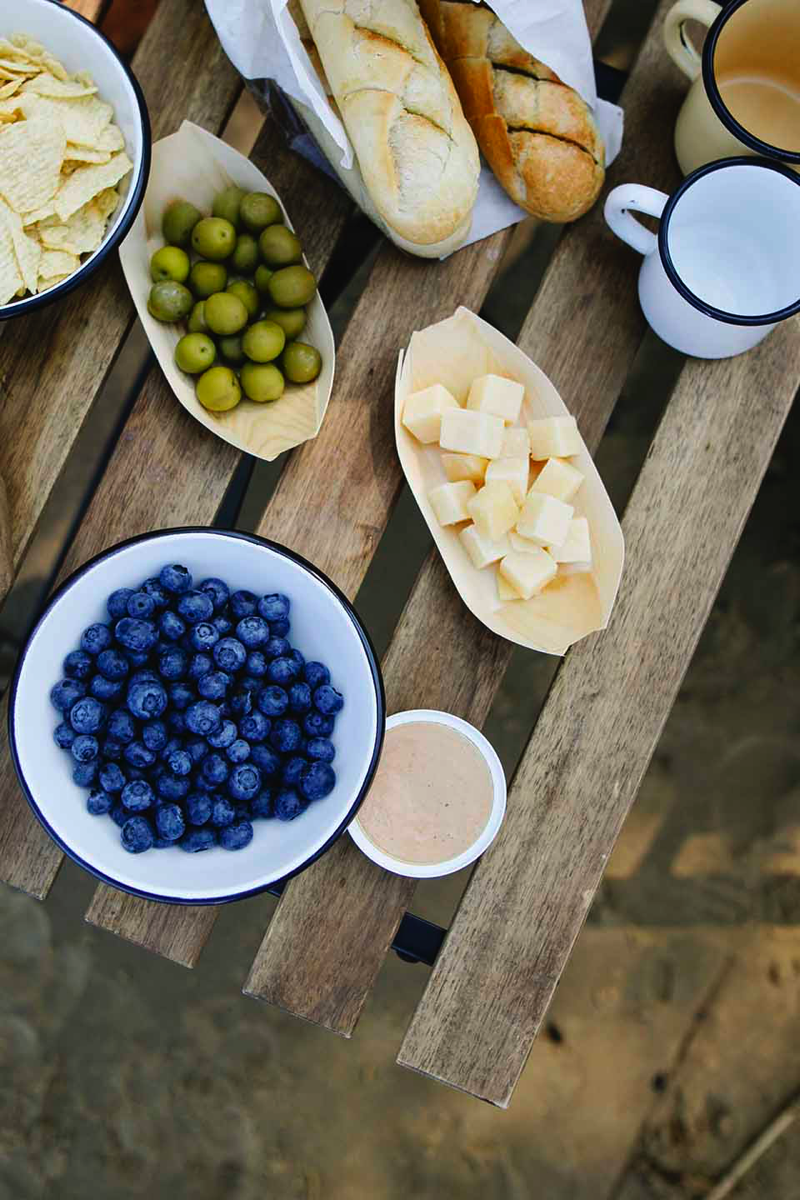 Served snacks during a picnic. Blueberries, cheese and olives