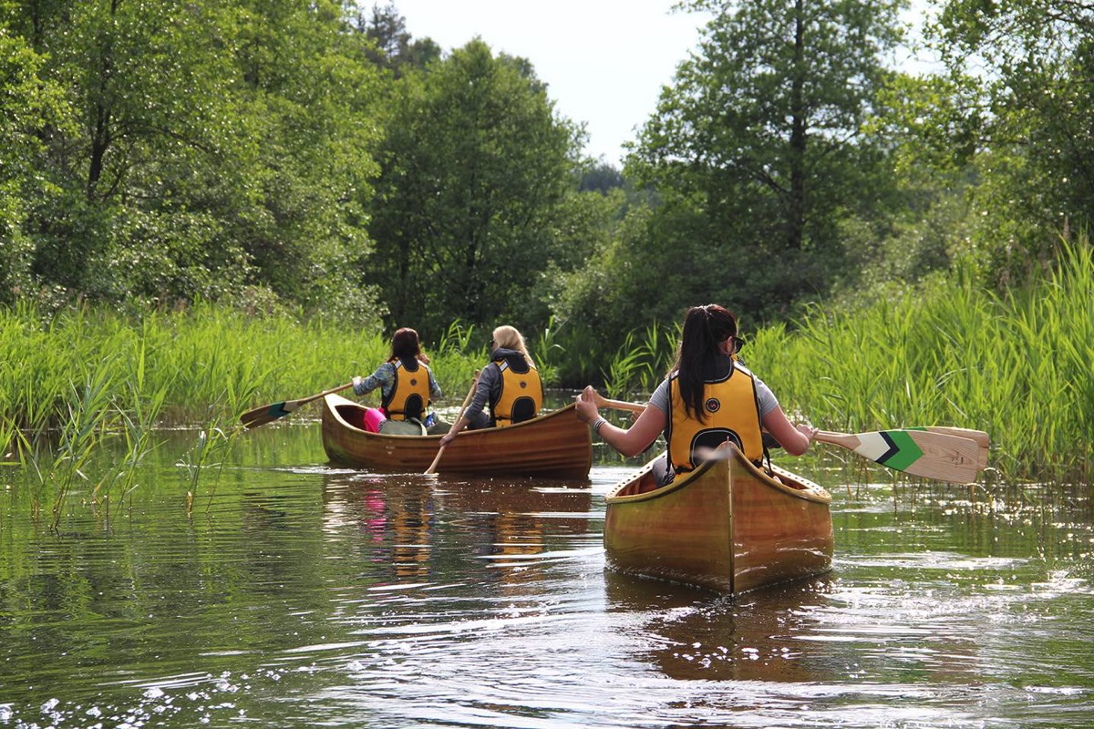 Ladies paddling canoe in Lithuania during canoe tour